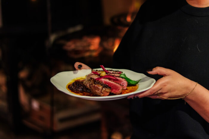 Assiette de viande grillée servie devant le brasero du restaurant COBA
