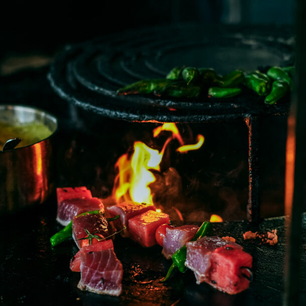 Brasero de COBA : braises, flammes et brochettes en cuisson