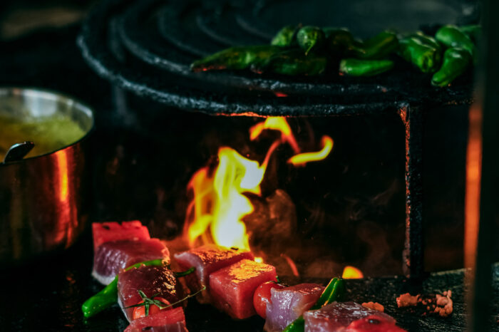 Brasero du restaurant COBA avec flammes et brochettes de thon en cuisson